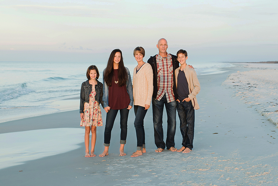 family standing on a beach